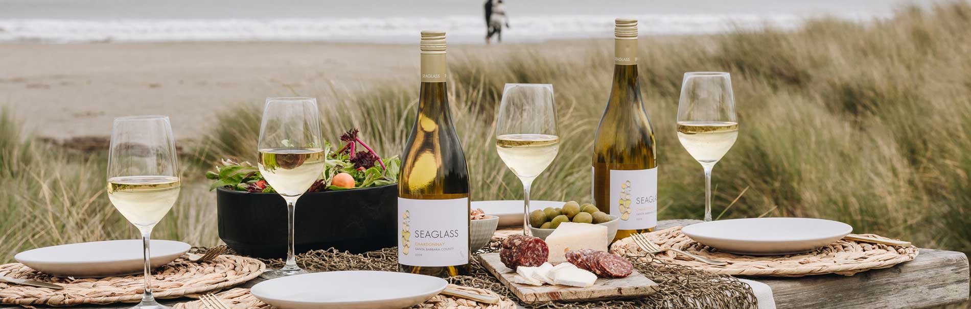 Plateau raffiné avec bouteille de vin blanc, saucisson, das un cadre idéal à partager au bord de la plage - photo libre de droit  Cave Le Pif en l'air à Rennes